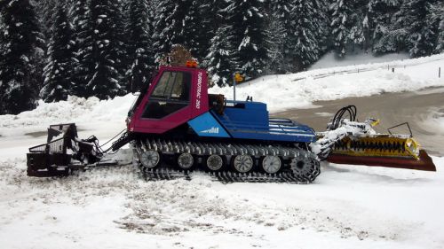 Ein dritter Pistenbully im oberen Bereich des Skihangs
