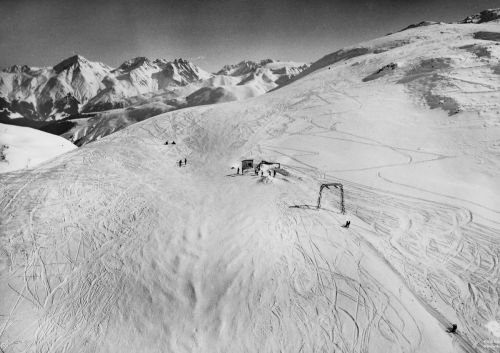 Postkarte aus den 1960er-Jahren (Archiv Uli Faulhaber). Die Bergstation liegt deutlich noch tiefer als beim Neubau 1966. Laut mündl. Auskunft von Fidel Monn (dessen Frau eine Schwester der Skiliftgründer, der Gebrüder Venzin, ist) im Januar 2007 habe Placi Soliva vom Restaurant Passhöhe den Venzins gesagt "Jungs, der Lift steht mitten auf der Piste, macht da mal was!" - 1966 ist der Lift dann verschoben worden, siehe unten.
